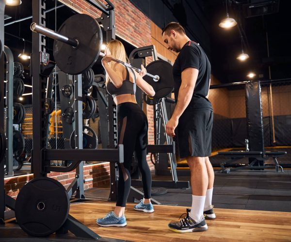 professional-gym-instructor-assisting-woman-at-the-gym-1.jpg